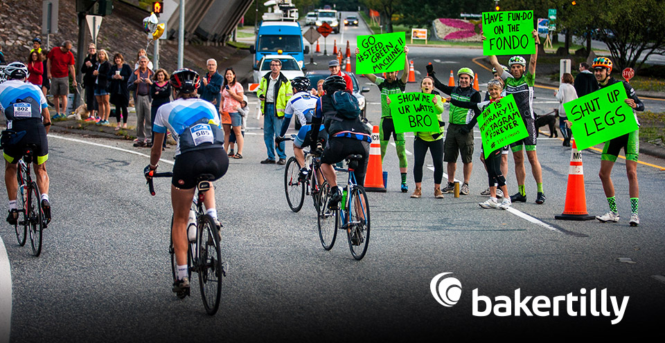 Cyclists taking on a Gran Fondo flanked by fans