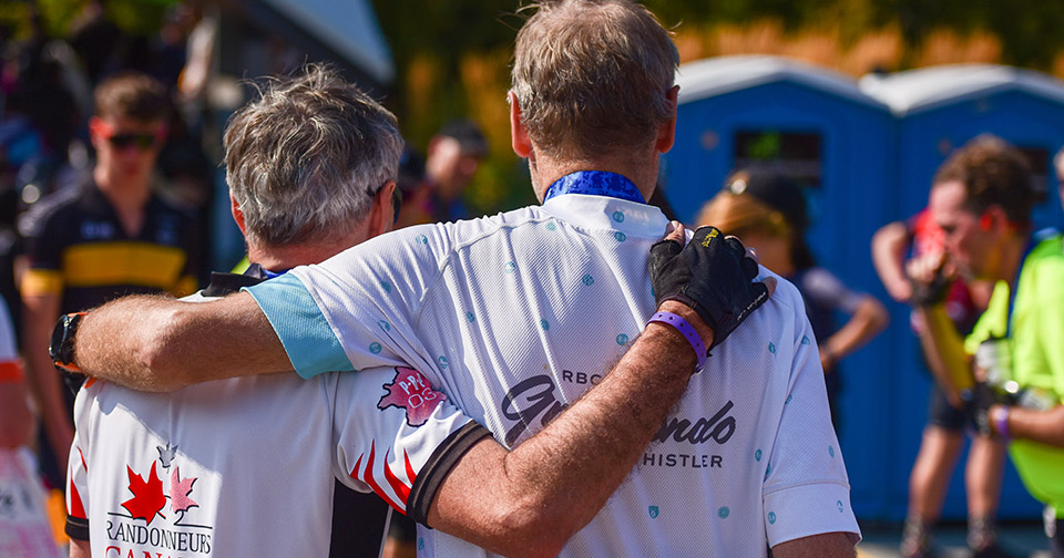 Cyclists with arms around each other